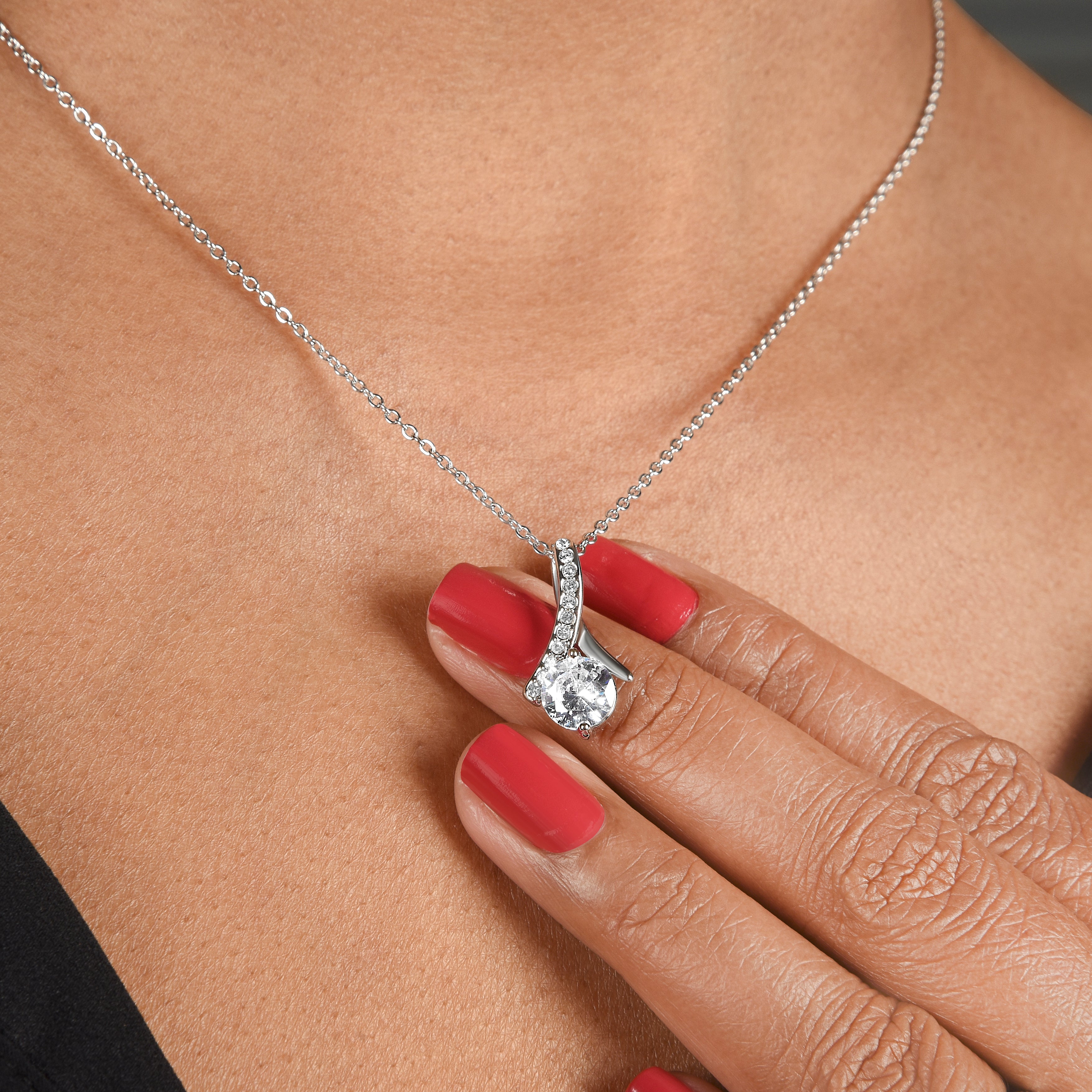 Silver-tone necklace with heart-shaped pendant, clear stone halo on clasp