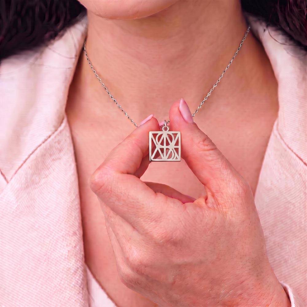 Silver-tone personalized monogram name necklace pendant on a chain, worn on chest