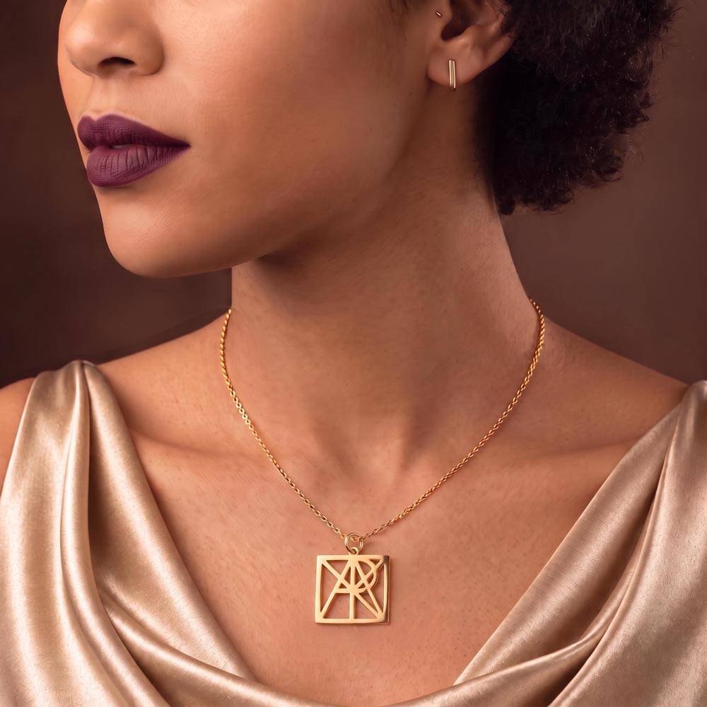 Gold-tone monogram name necklace pendant on chain, worn on neckline