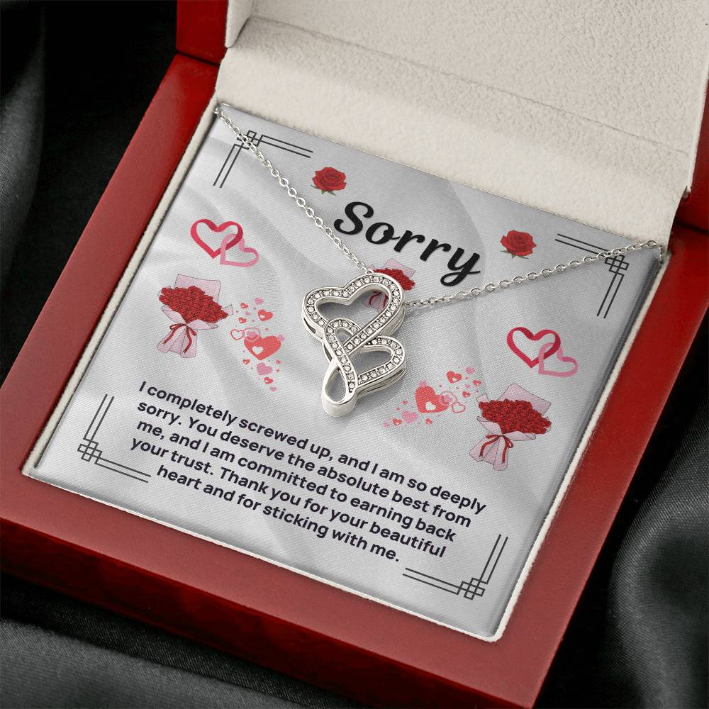Heart pendant necklace in silver tone, displayed in red jewelry box with card