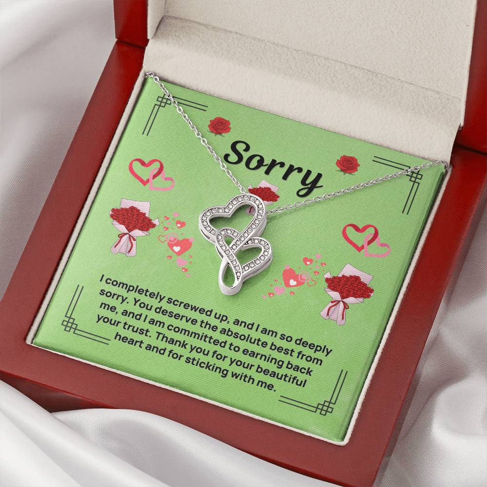 Heart infinity pendant necklace with sparkling stones, shown in green card inside red box