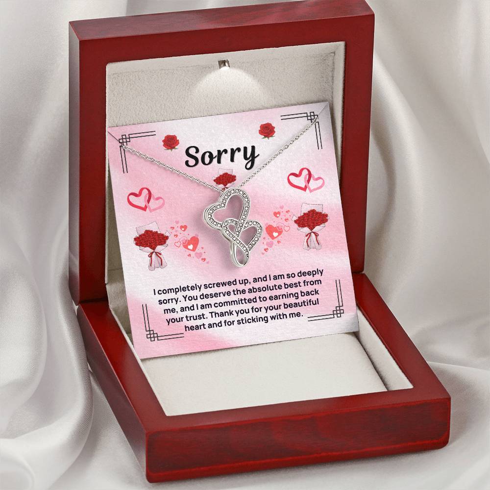 Heart pendant necklace in an open red gift box, silver-tone chain with clear-stone hearts
