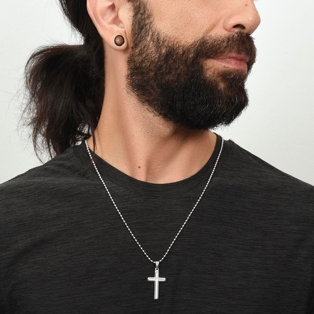 Silver cross pendant necklace worn by a man with beard and long hair