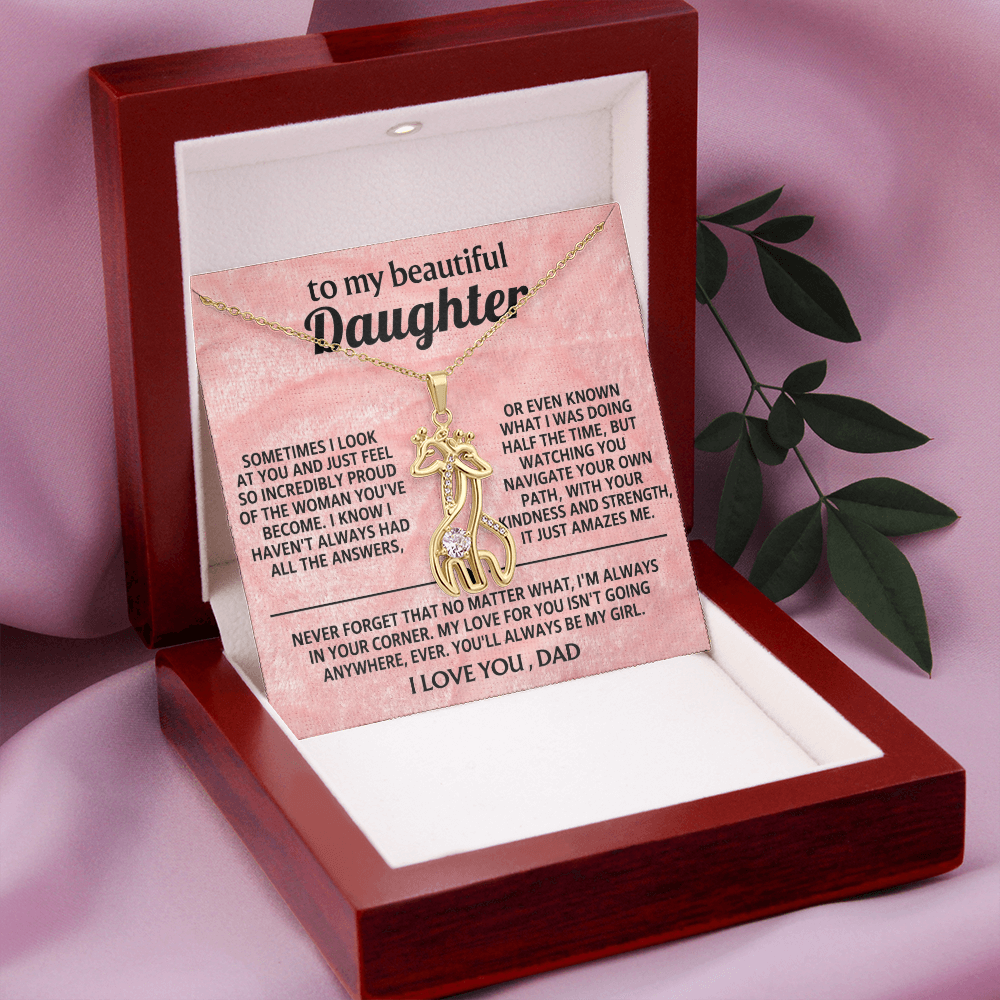 Necklace resting in open gift box with giraffe pendant and message card