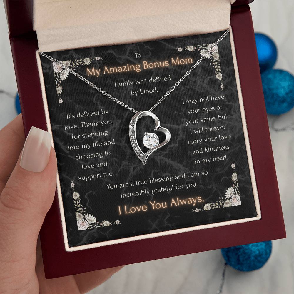 Silver heart pendant necklace with clear stone center, shown on a message card in box