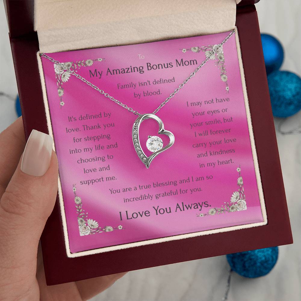 Silver heart pendant necklace on pink message card in gift box, held in hand