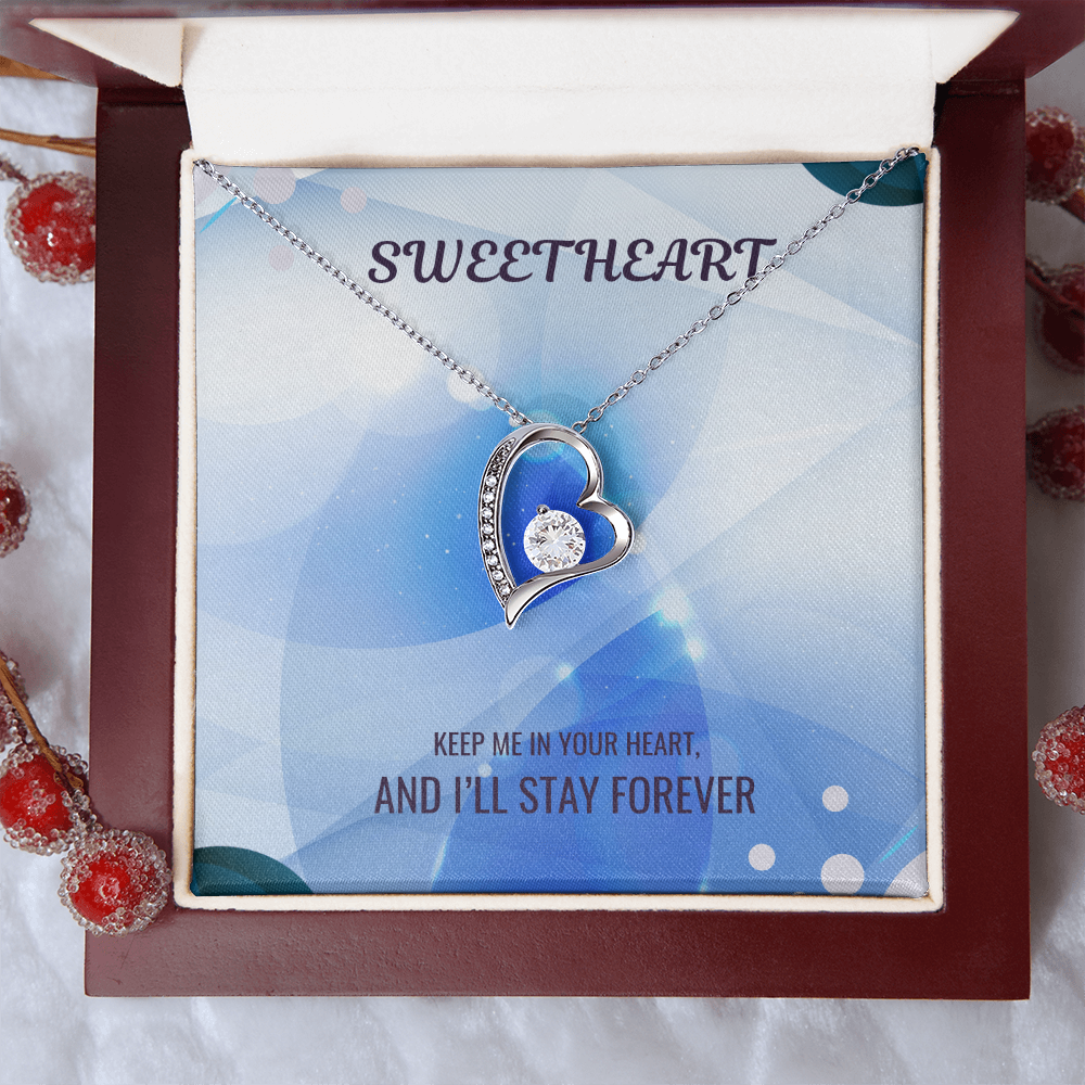 Silver heart pendant necklace in open red gift box with message card