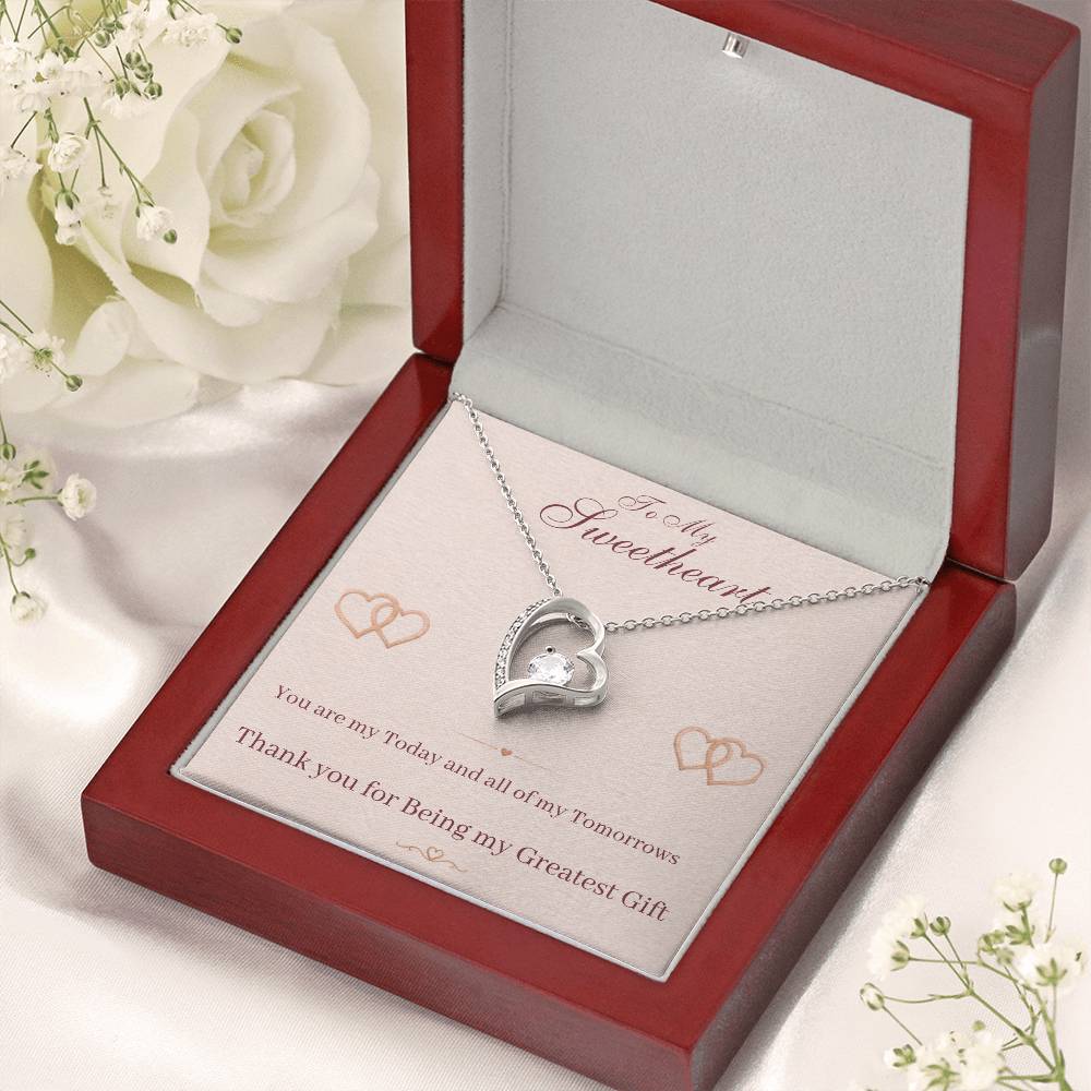 Heart pendant necklace with silver-tone chain and small center stone in red gift box