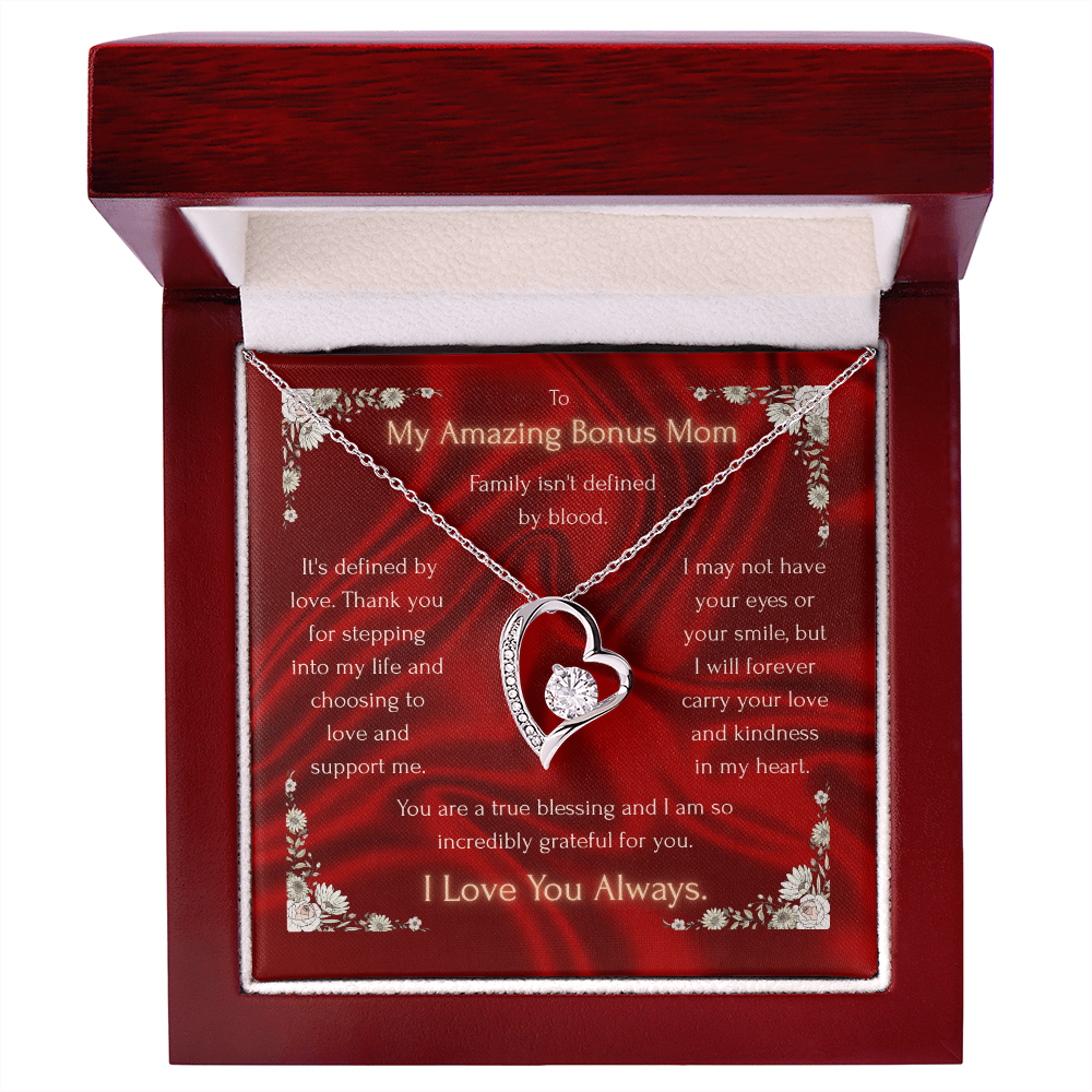 Gold heart pendant necklace on red floral card inside closed gift box with red lid.