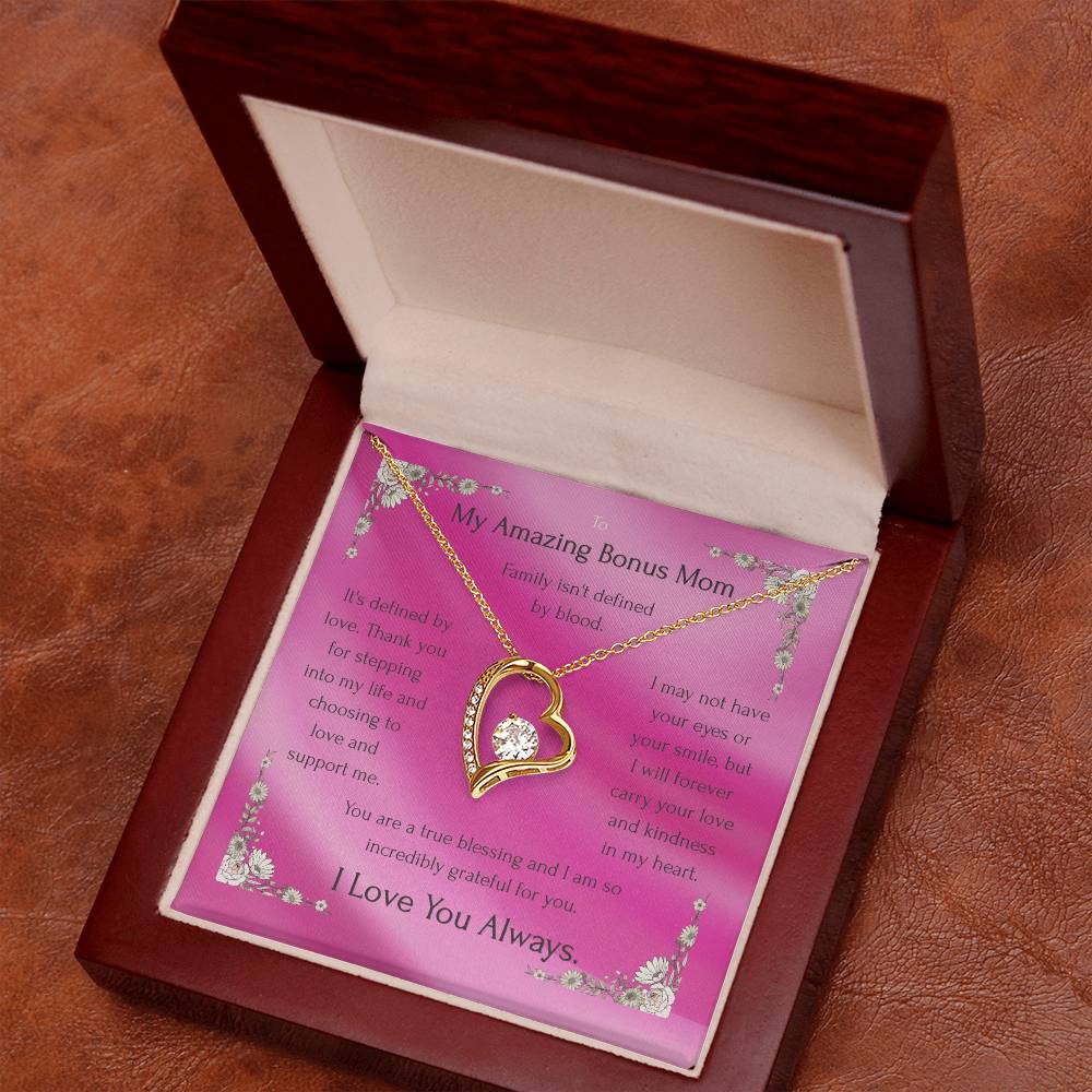 Gold heart pendant necklace resting on pink message card inside an open gift box