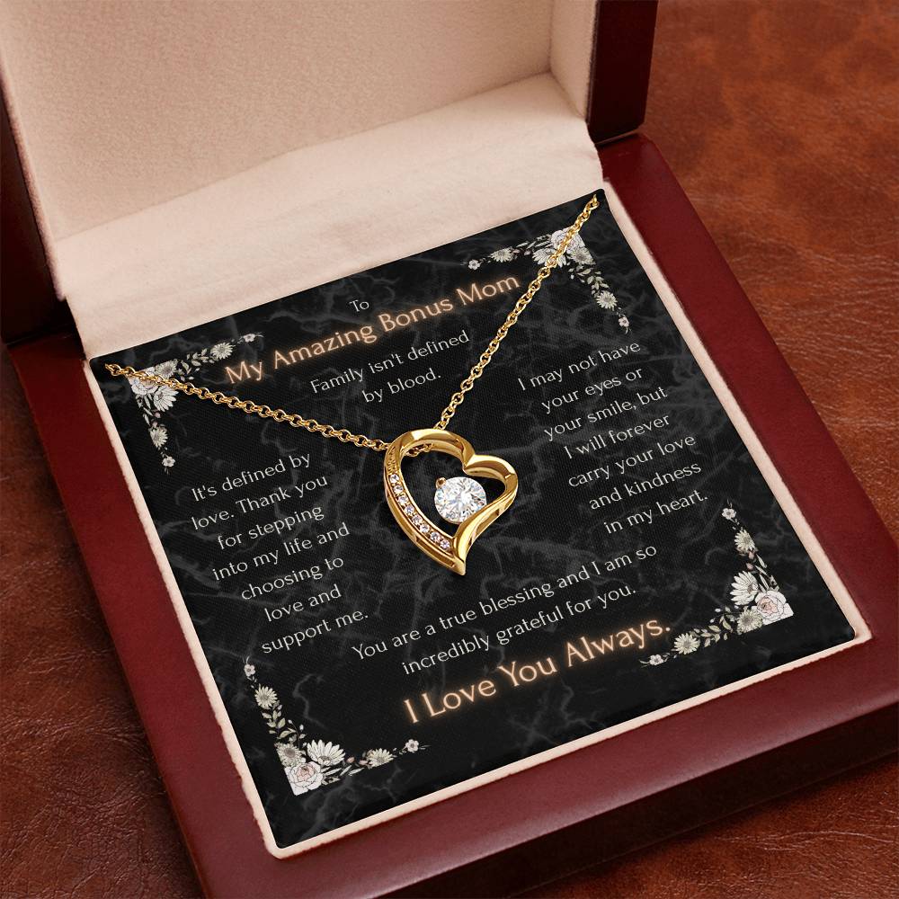 Gold heart pendant necklace with clear center stone and chain on a message card