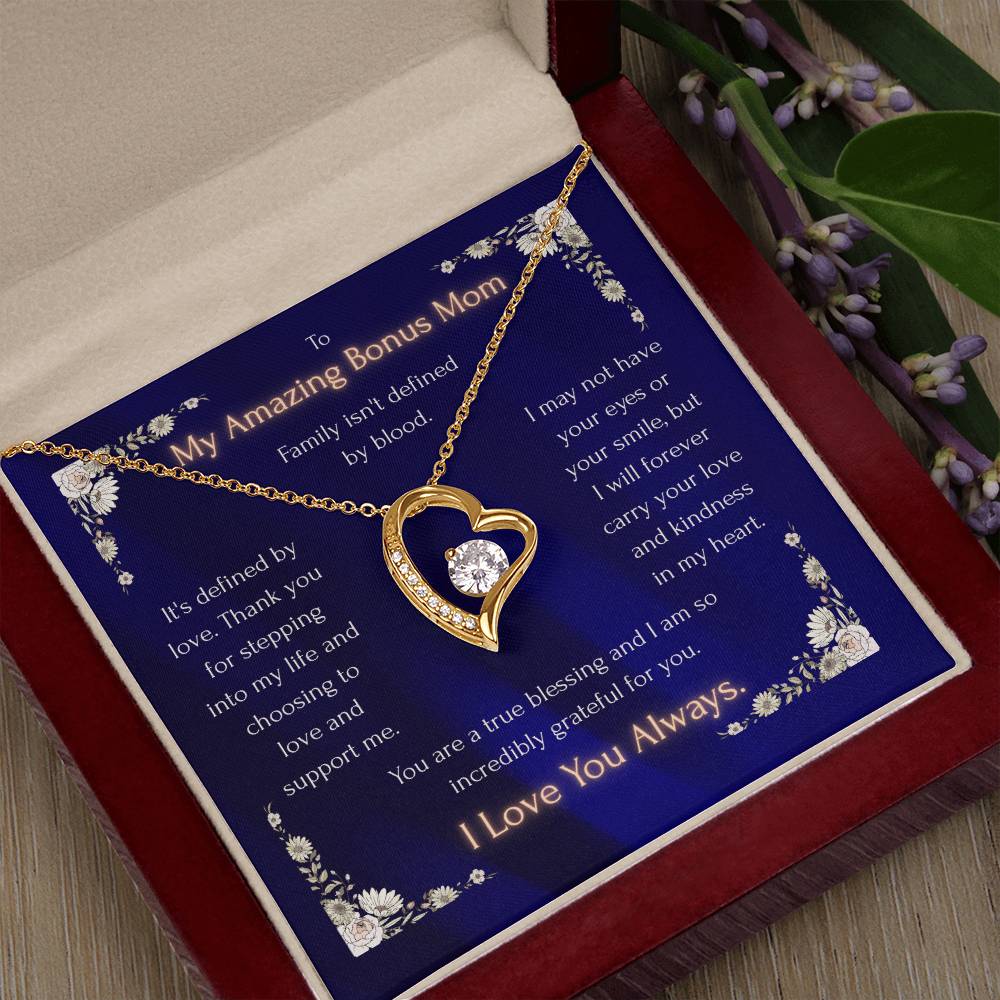 Gold-tone heart pendant necklace with blue enamel detail beside gift card