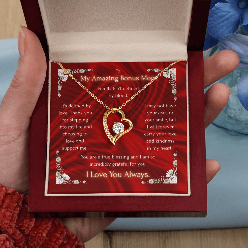 Hands holding a red gift box with gold-tone heart pendant necklace and chain