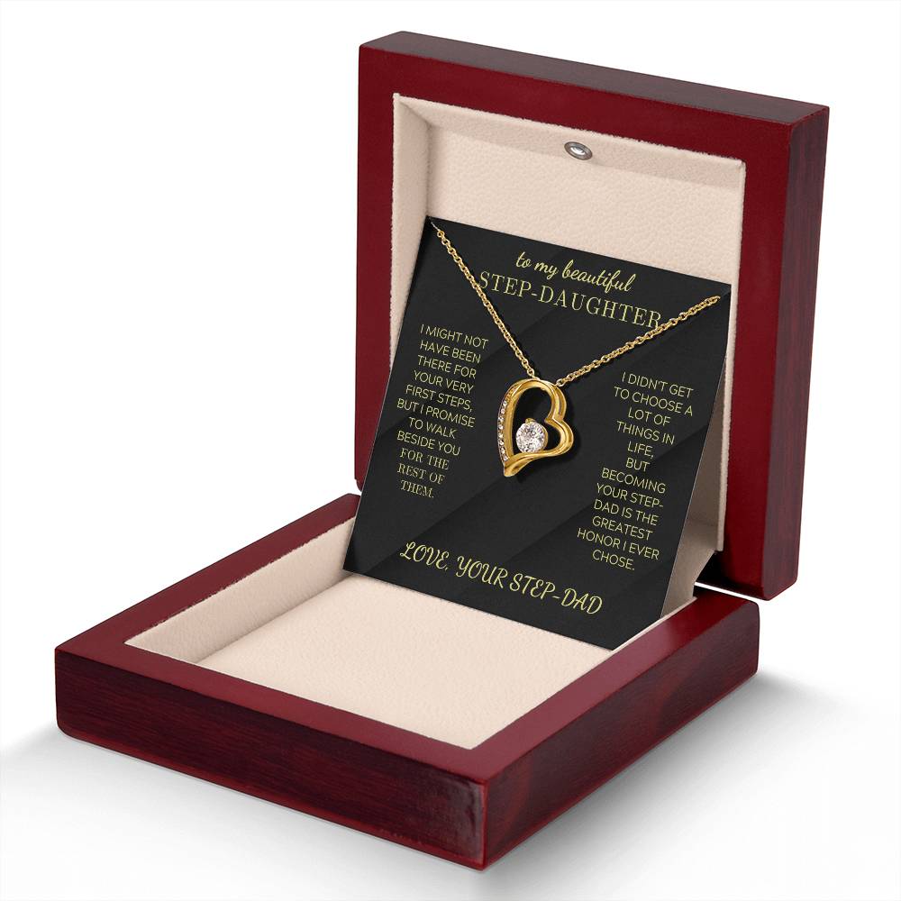 Gold-tone heart pendant necklace with clear stone, displayed in maroon gift box