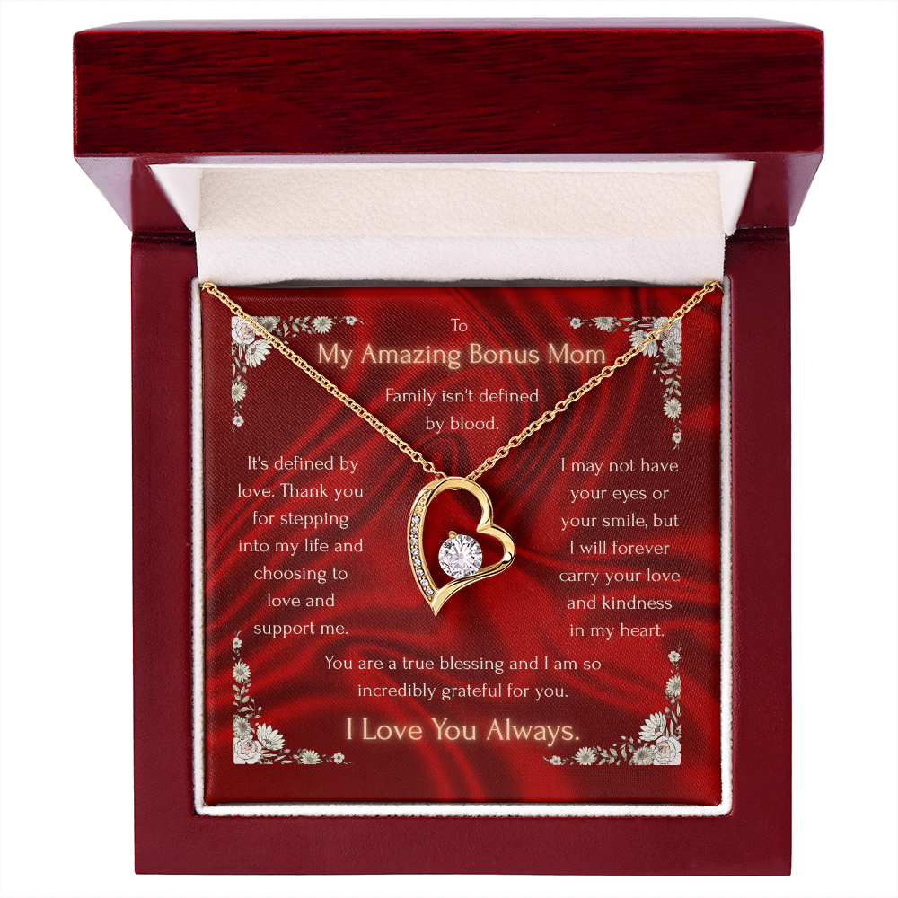 Gold heart pendant necklace on red floral card inside closed gift box with red lid.