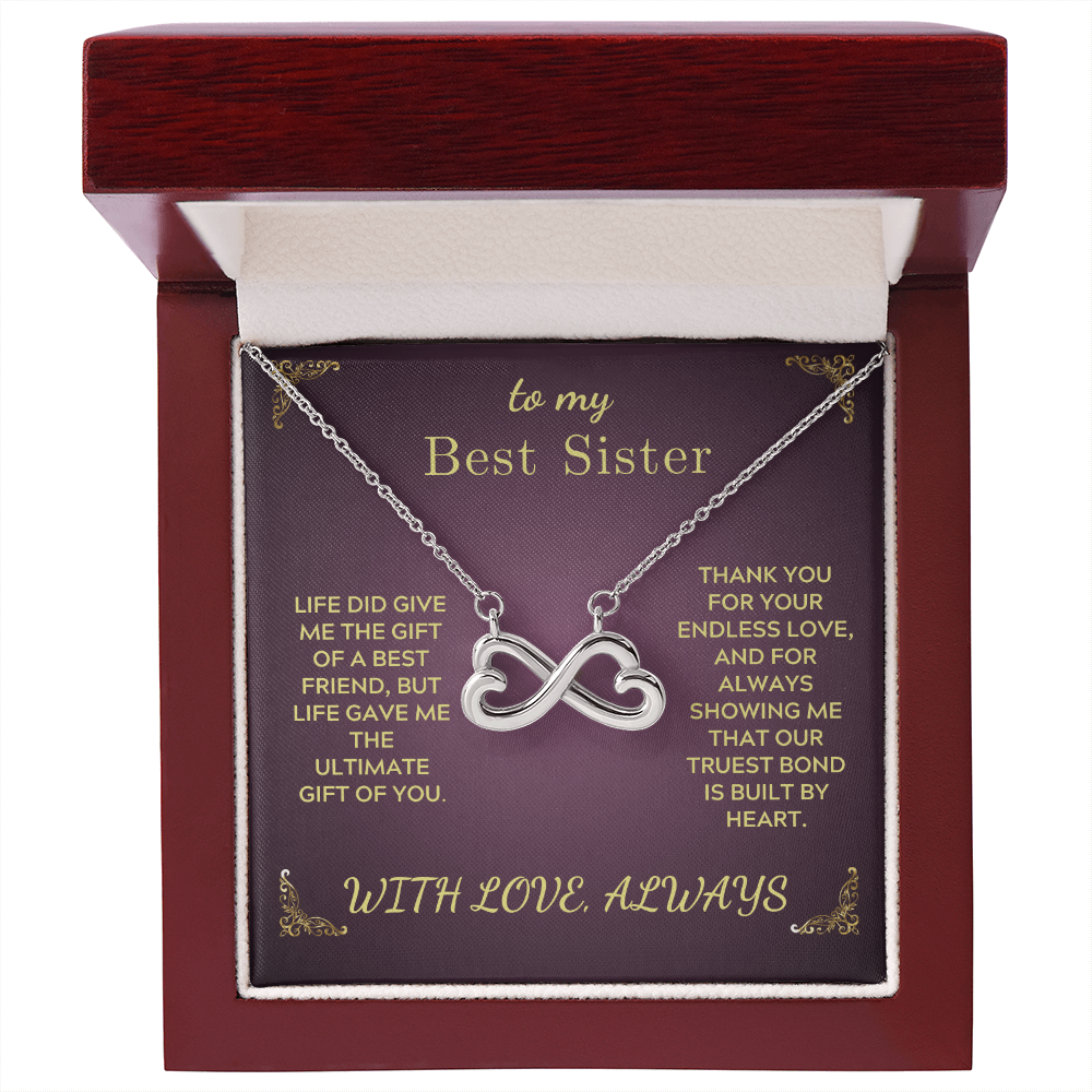 Silver heart-and-infinity pendant necklace inside red presentation box