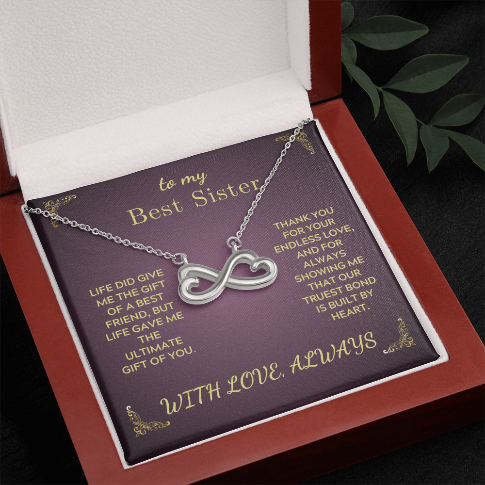 Silver heart-and-infinity pendant necklace on purple insert inside red box