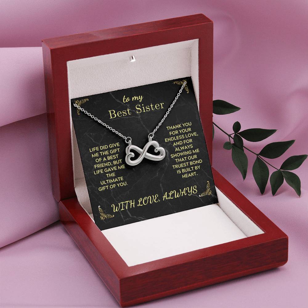 Infinity heart pendant necklace in a red gift box with black “Best Sister” card