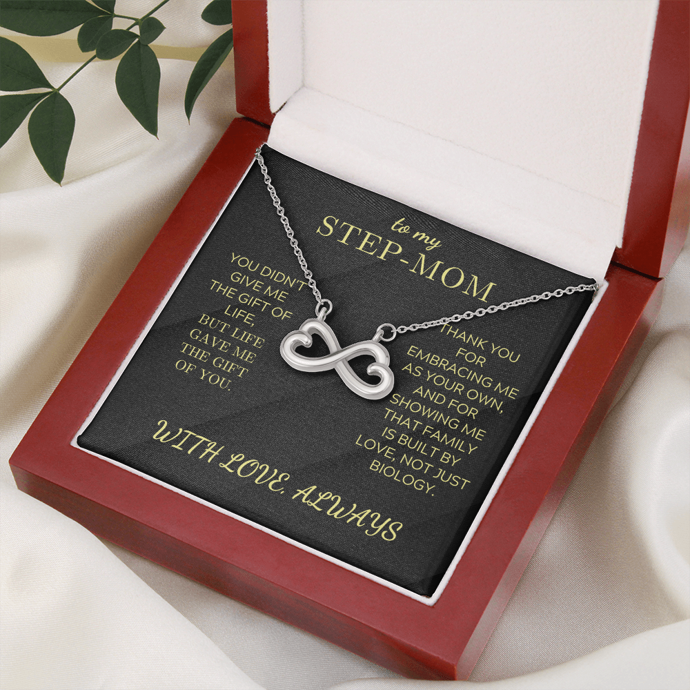 Silver infinity heart pendant necklace inside an open red gift box on a white surface