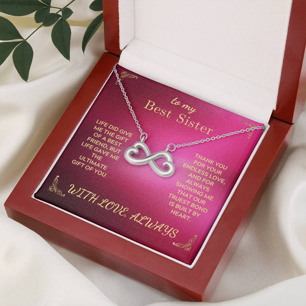 Infinity-heart necklace in gift box resting on fabric