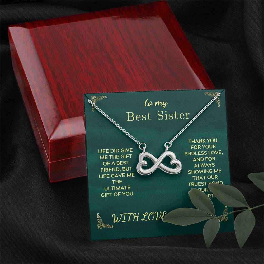 Green gift card box with silver heart infinity necklace inside a red wooden case.