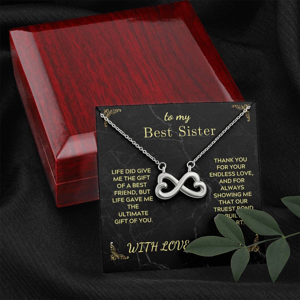 Infinity heart pendant necklace displayed in a red wooden gift box with black card