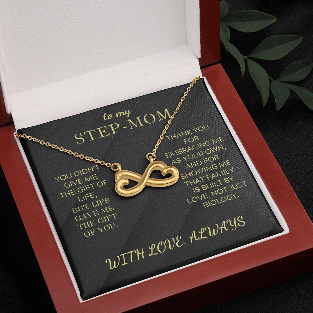 Gold infinity heart pendant necklace on black card inside a red gift box
