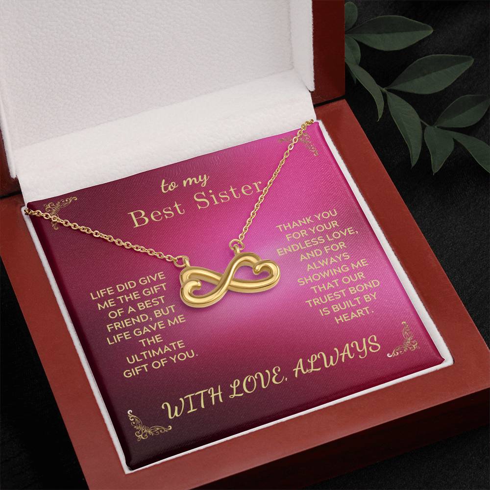 Gold-tone infinity heart pendant necklace on rose card inside open gift box