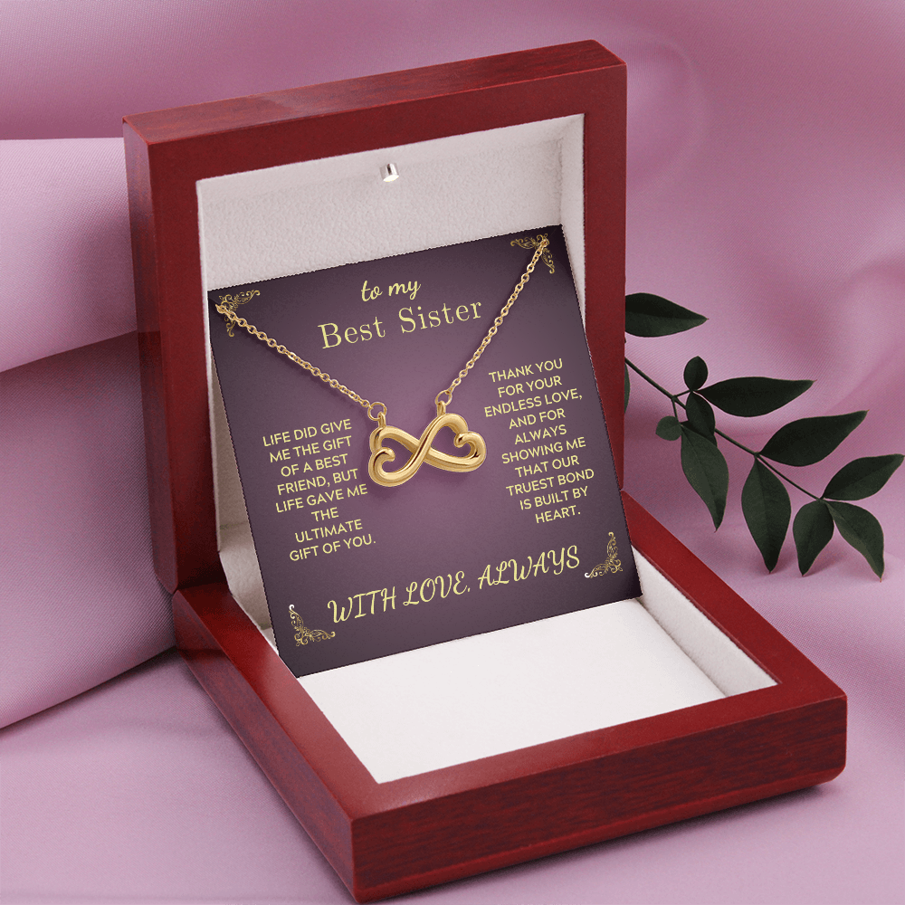 Gold infinity heart necklace on purple card inside open red gift box