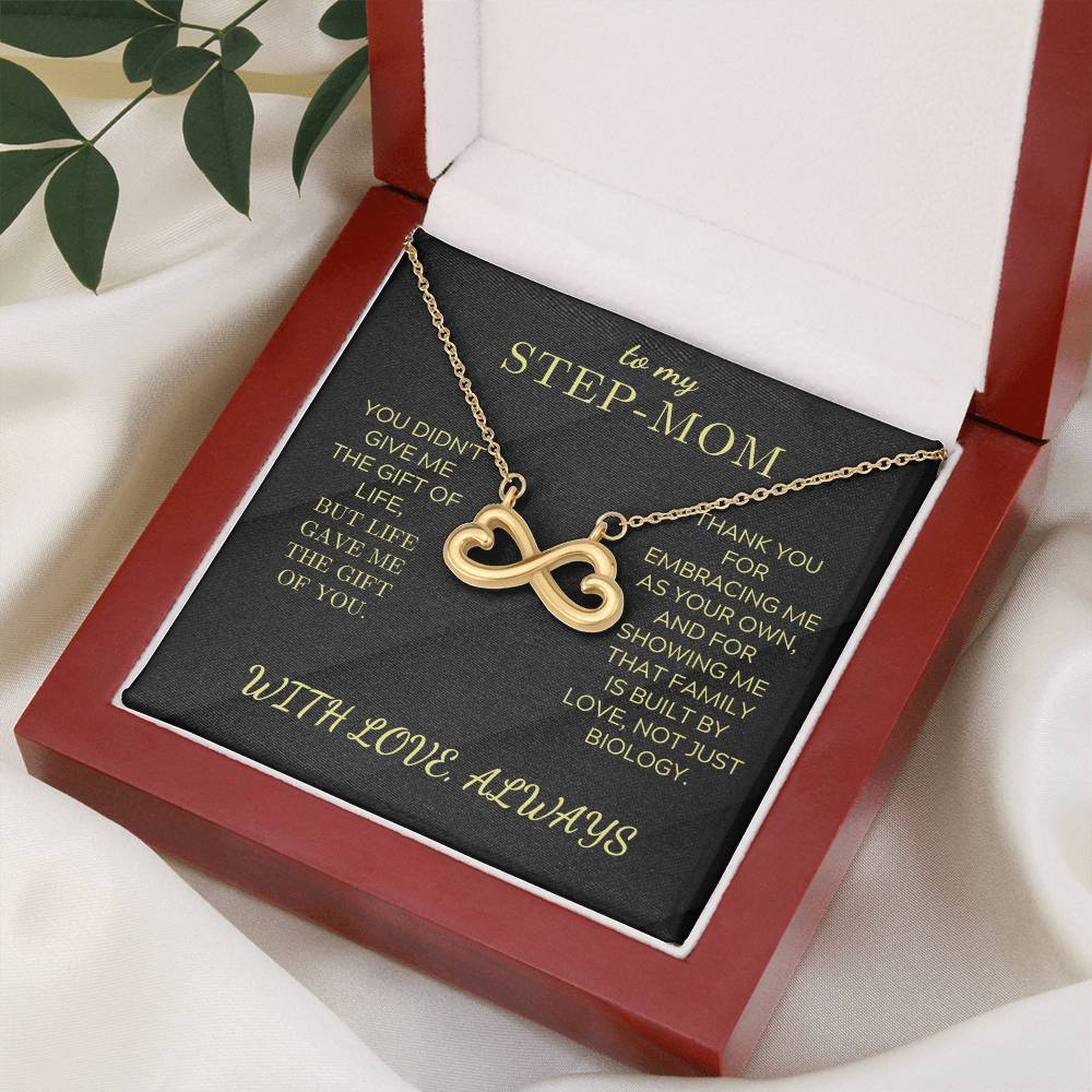 Open gift box with gold infinity heart necklace and black “STEP-MOM” card