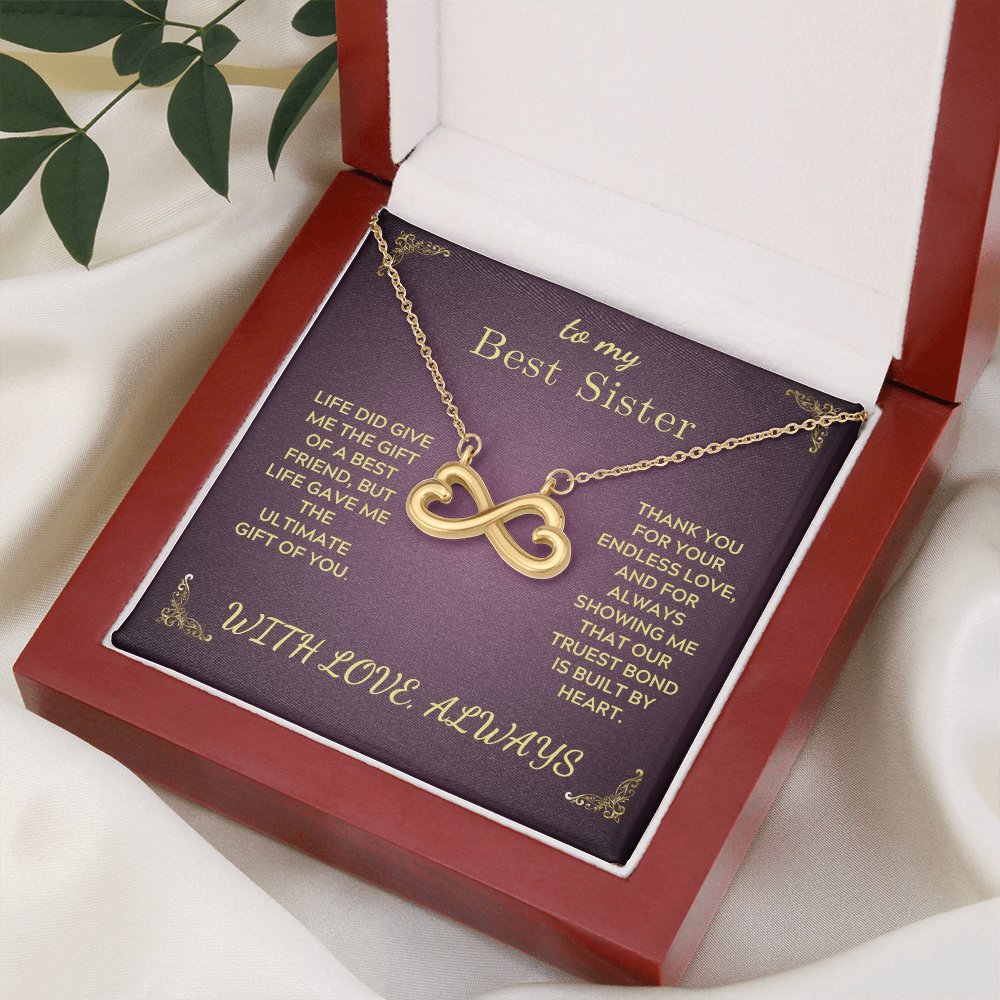 Open red gift box with purple card and gold infinity heart necklace on chain