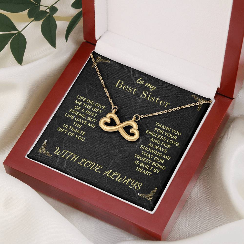 Gold infinity heart pendant necklace on black card inside red gift box