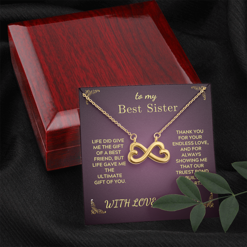 Gold infinity heart necklace on purple card inside red wooden gift box