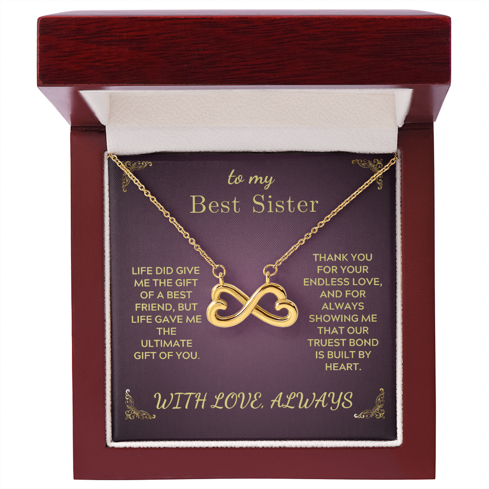 Gold heart-and-infinity pendant necklace inside red presentation box