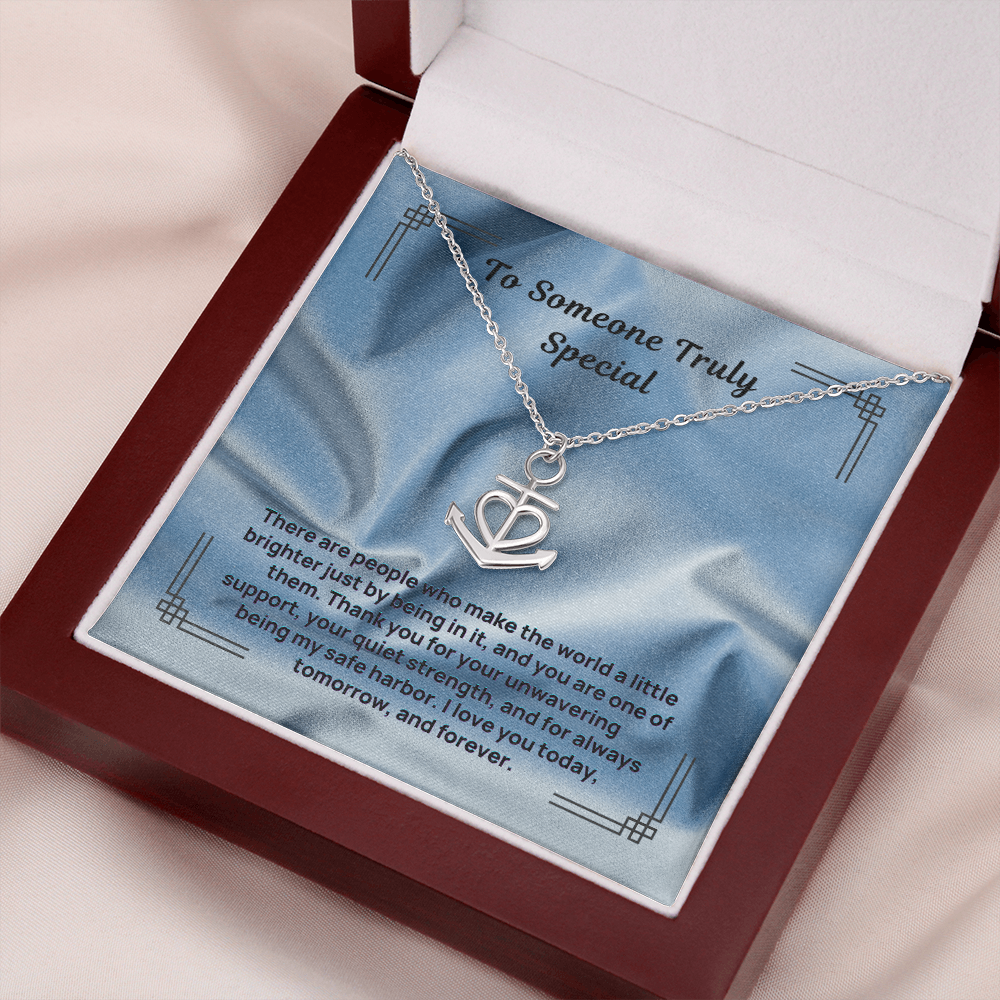 Silver anchor and heart pendant necklace on a chain inside a gift box.