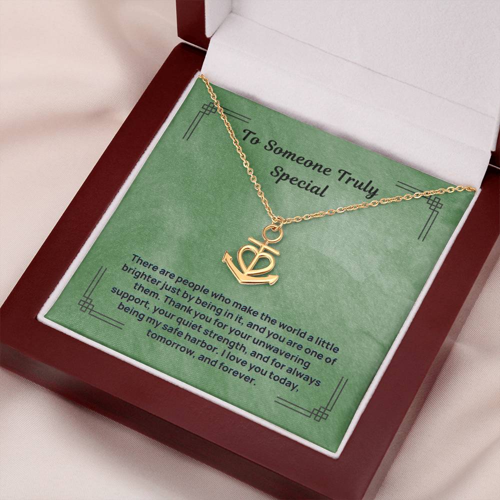 Gold anchor safe harbor pendant necklace in open jewelry box, angled