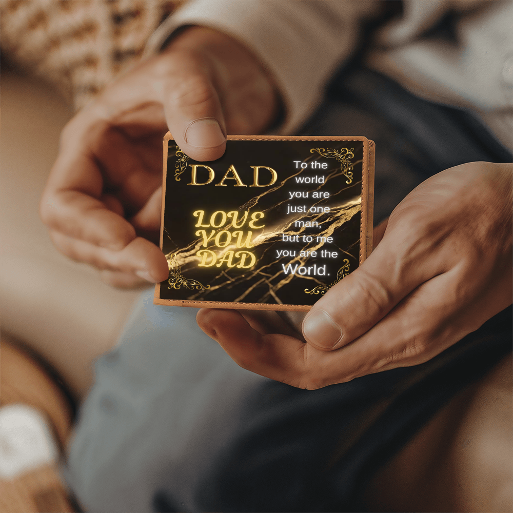 Tan leather wallet with gold 'DAD' quote panel, held in hands