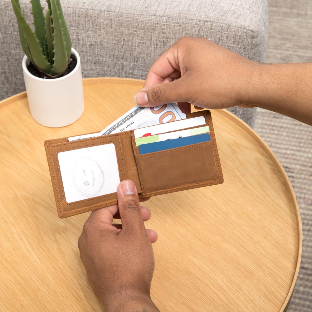 Brown leather wallet open showing a clear card sleeve and side credit card slot
