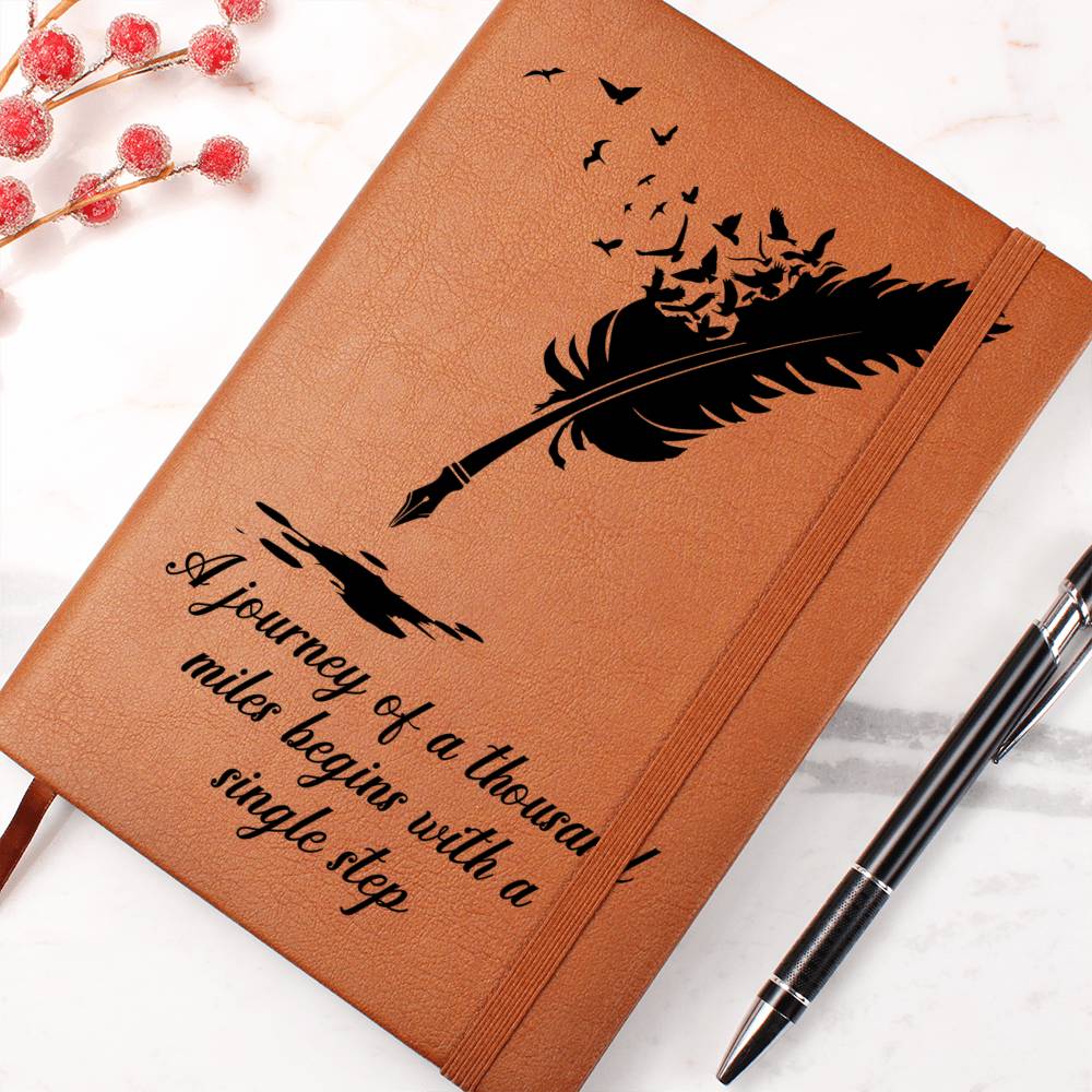 Brown graphic journal with feather graphic, quote text, and elastic band