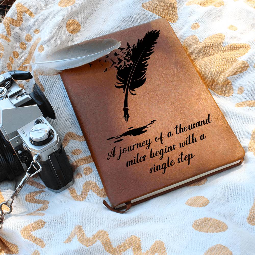 Brown graphic journal with feather graphic, quote text, and elastic band