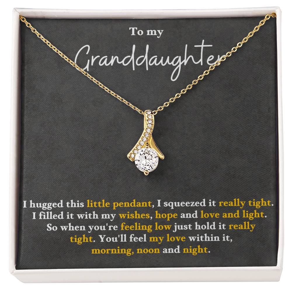 Gold-tone pendant necklace in a gift box, with teardrop charm and small clear stones.