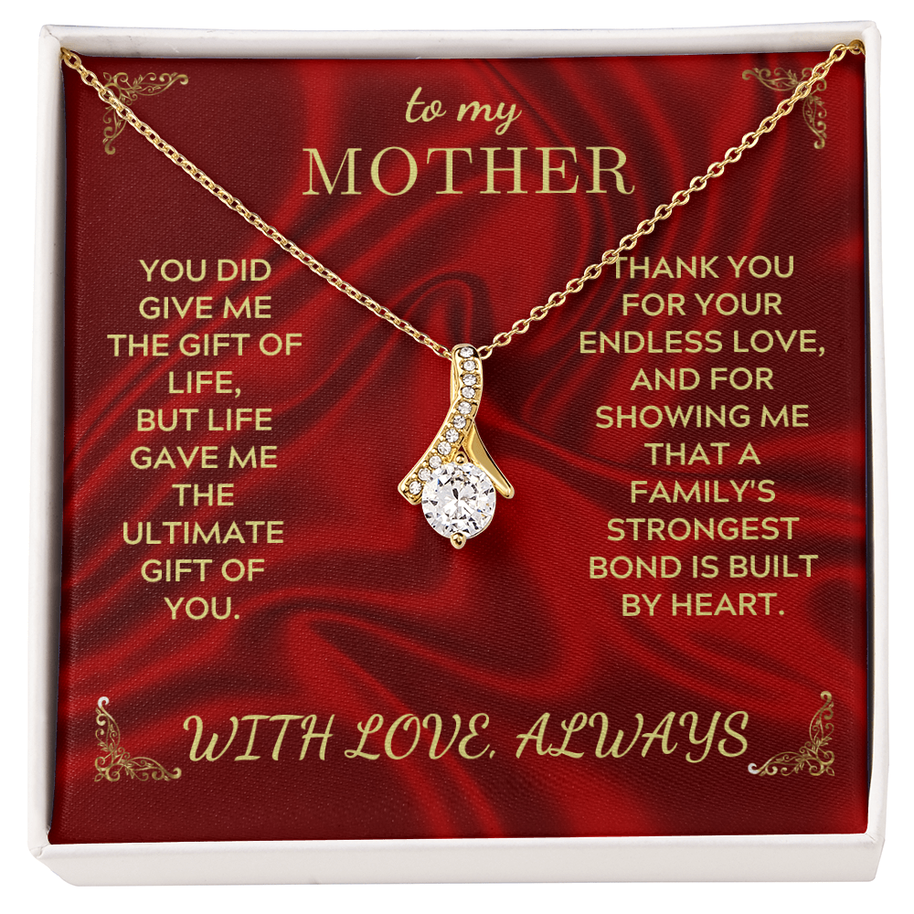 Gold-tone necklace with teardrop crystal heart pendant on red gift box