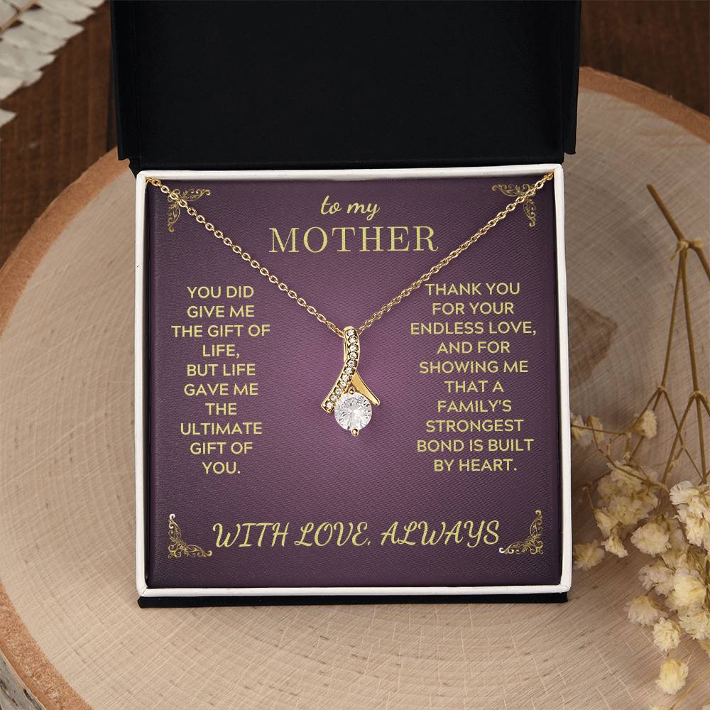 Gold-tone pendant necklace in a purple gift box with decorative message text