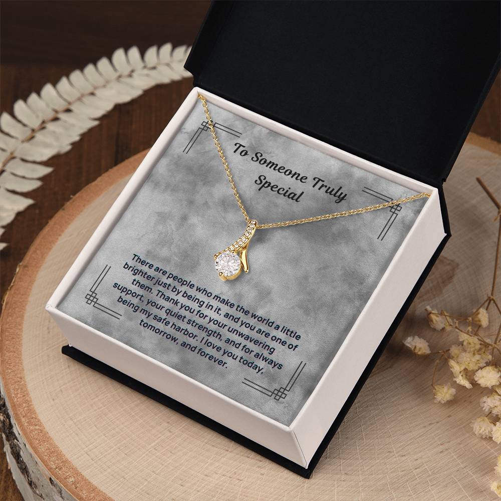Gold-tone necklace with teardrop pendant, displayed in open black gift box