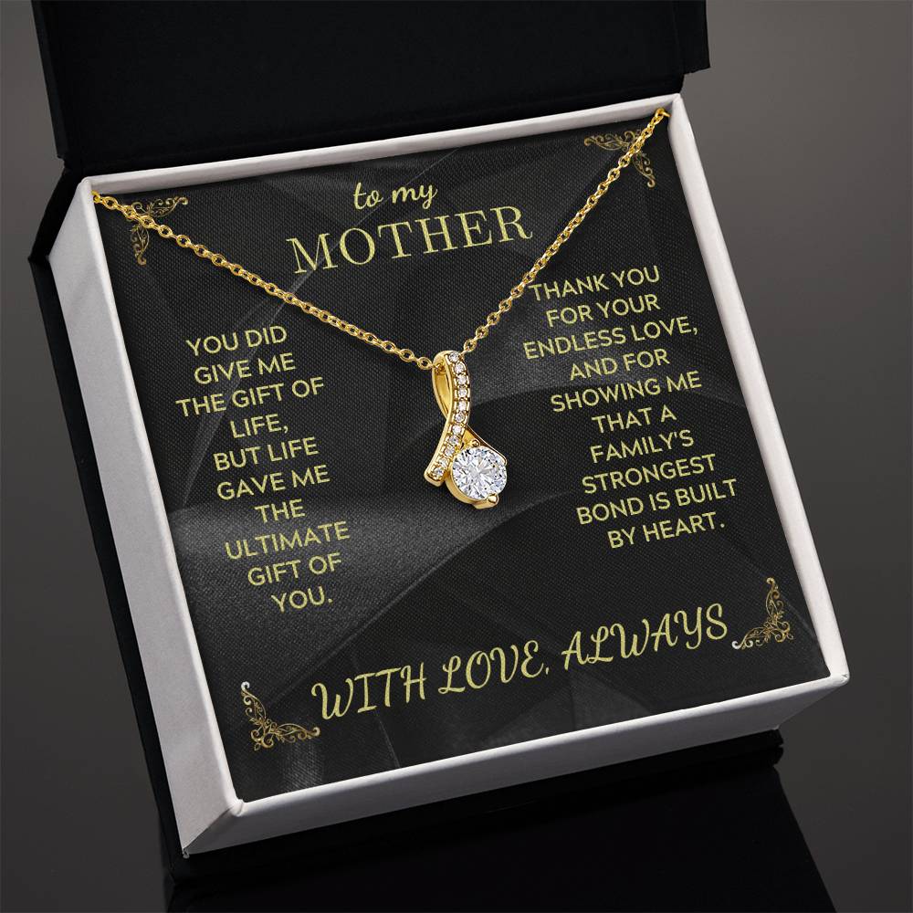 Gold-tone teardrop charm necklace with rhinestone cluster and chain, inside white gift box