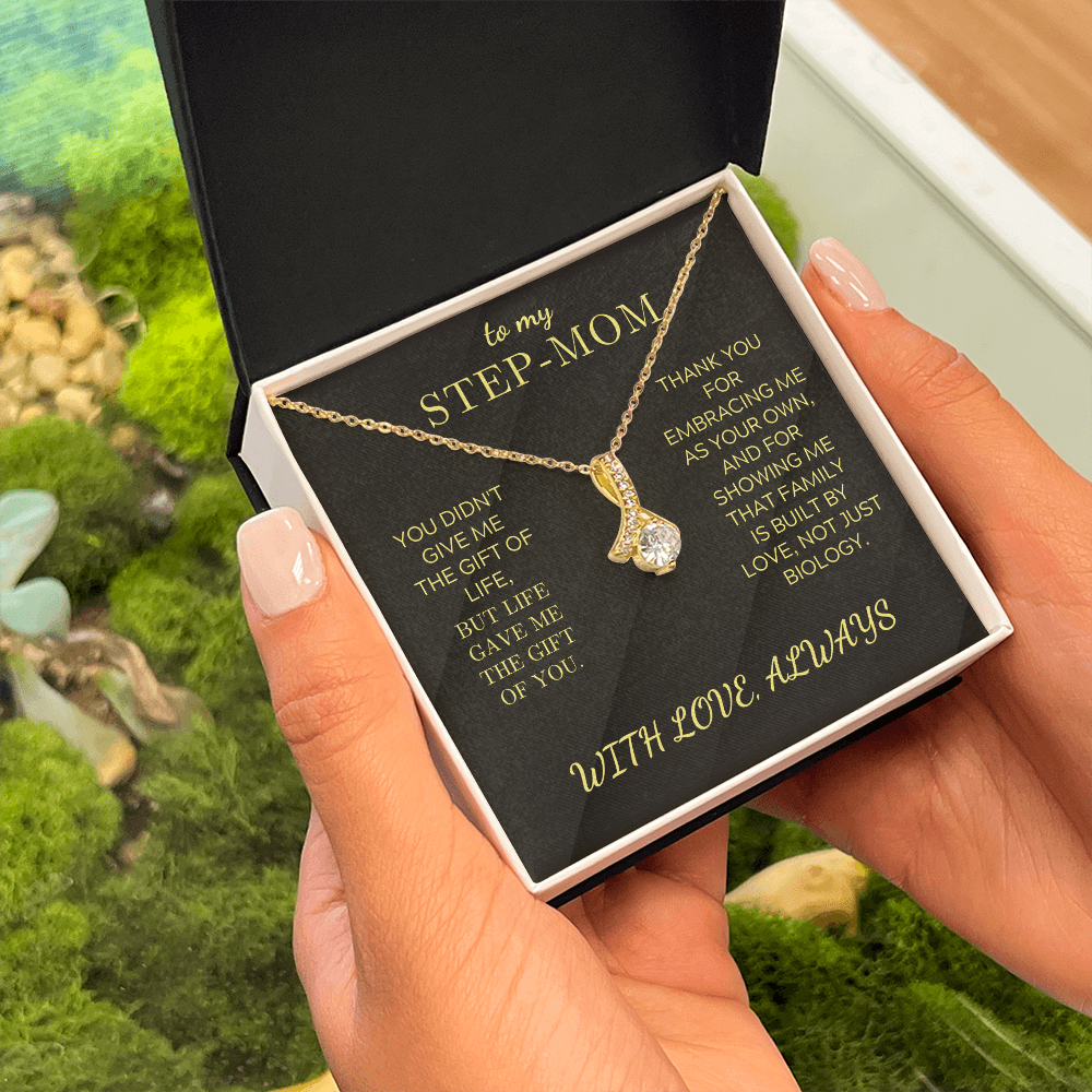Gold-toned necklace with teardrop pendant and clear stones, gift box