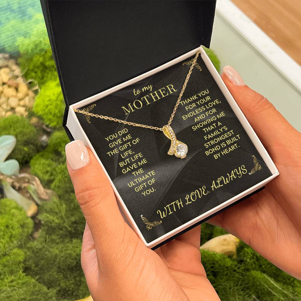 Mother necklace in open black gift box, gold chain with teardrop heart charm pendant on black card