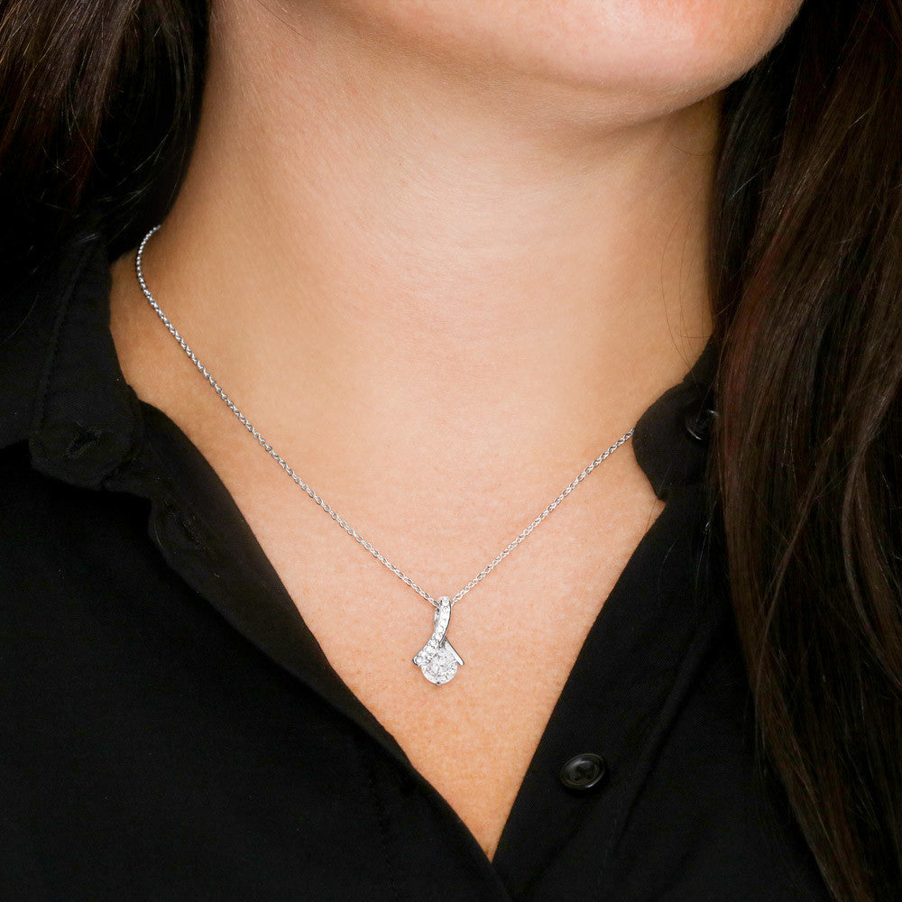 Silver-tone chain necklace with crystal heart pendant and dangling bow detail