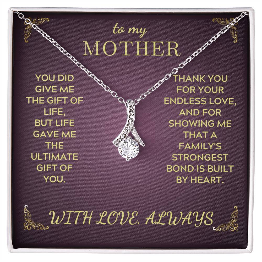 Silver-tone pendant necklace with teardrop heart charm on purple gift box tray