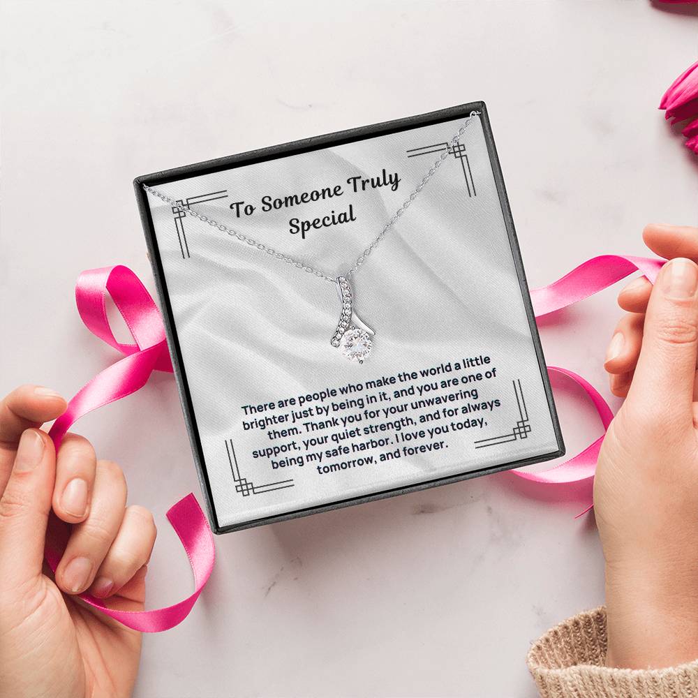 Silver-tone necklace with small teardrop pendant, displayed in square gift box